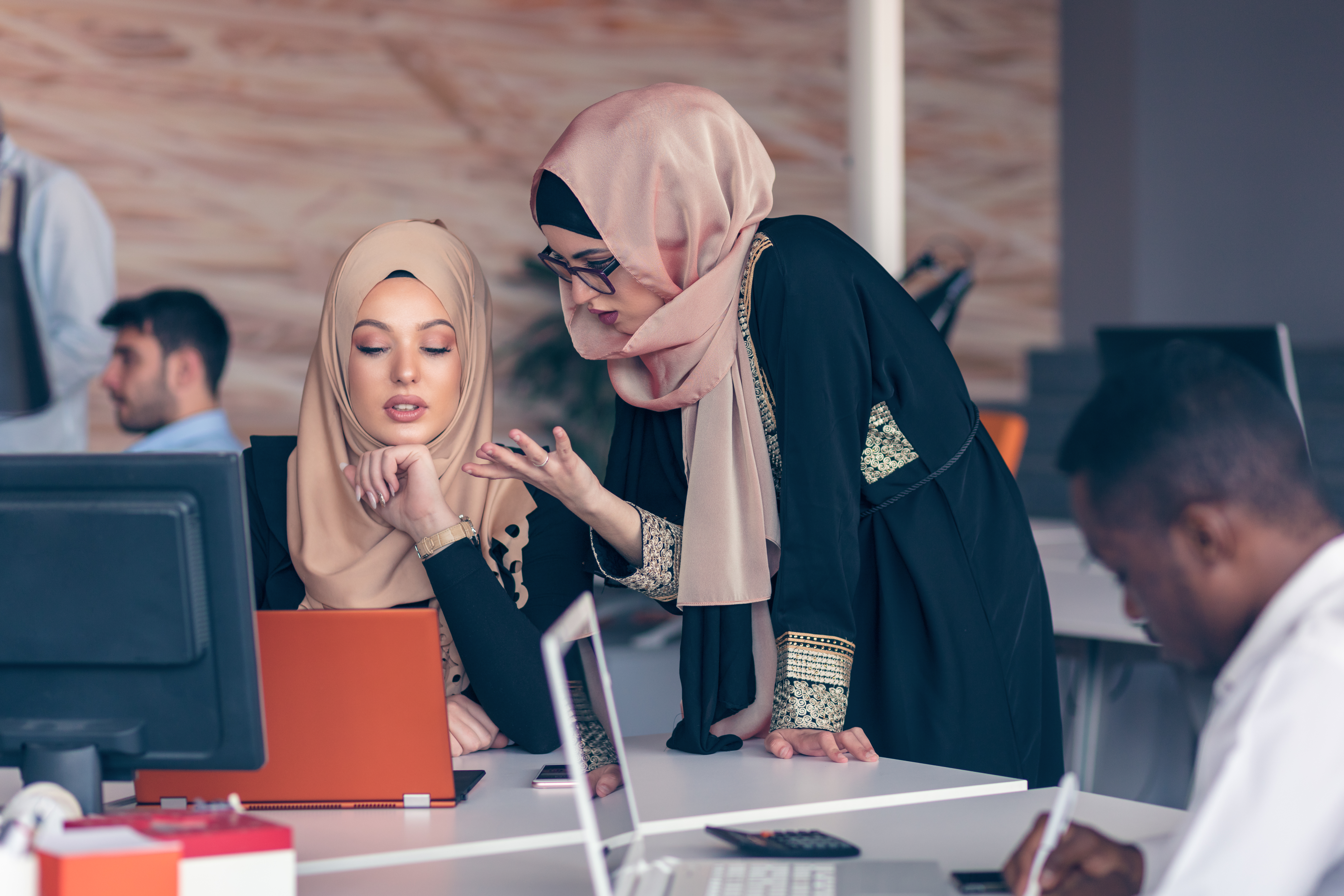 Two woman with hijab working on laptop in office